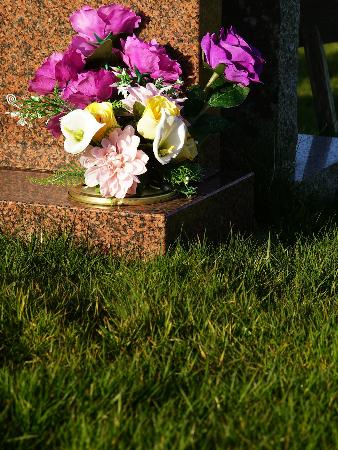 Granite headstone with flowers in a cemetery
